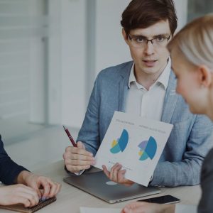 Three professionals discussing charts in a meeting.