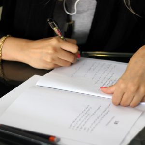 a person writing on a piece of paper
